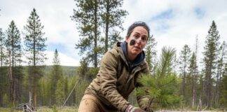 Volunteer Vacations: Travel While Giving Back to Nature Volunteer planting sapling in mud, looking surprised.